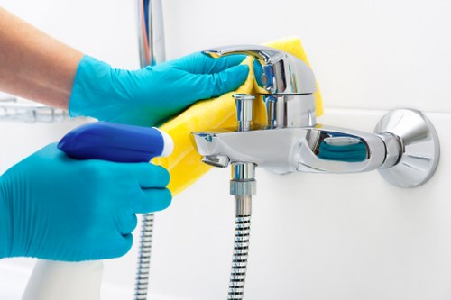 Cleaner handling communal office kitchen and washroom areas in W1T